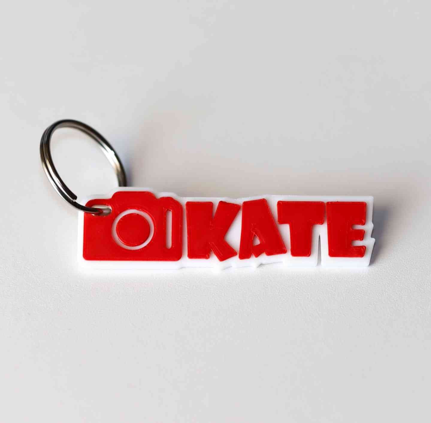 Μπρελόκ «Kate» — 3D εκτυπωμένο κόκκινο/λευκό με εικονίδιο φωτογραφικής μηχανής